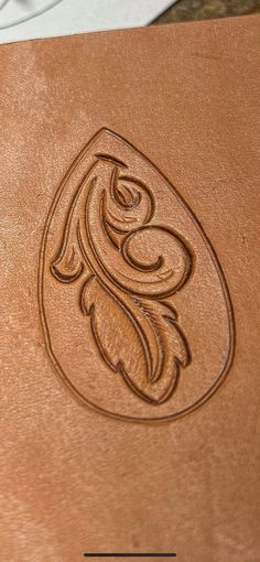 a close up of a leather case with a flower design on the front and side