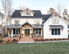 a large white house with black roof and windows