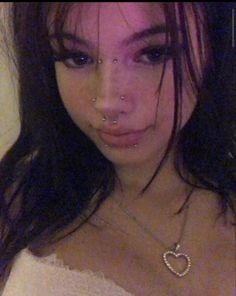 a woman with piercings on her nose and chest