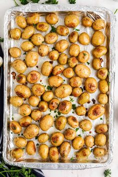 baked potatoes in a baking pan with parsley on the side, ready to be eaten