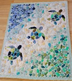 a sea turtle quilt is displayed on the floor