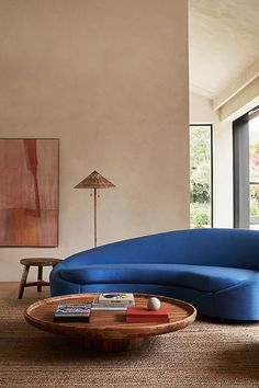 a living room with a blue couch and coffee table in front of a large window