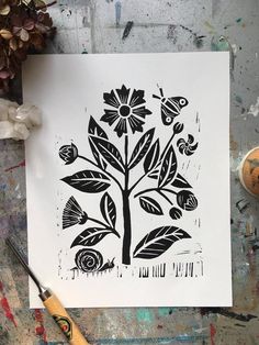 a drawing of a tree with flowers and butterflies on it next to paintbrushes