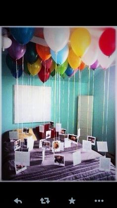 balloons are floating in the air over a table with pictures and photos on it's sides