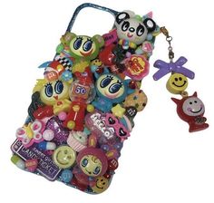 a cell phone case with lots of small toys on it's back and an animal keychain hanging from the front