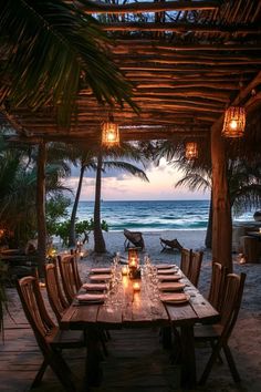 an outdoor dining area with candles lit on the table and ocean view in the background