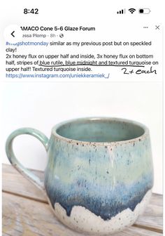 a blue and white coffee cup sitting on top of a wooden table next to a tweet