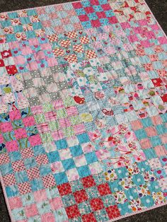 a patchwork quilt is laying on the ground