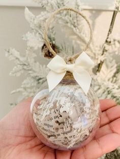 a hand holding a glass ornament with writing on it