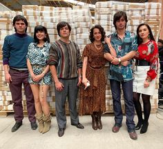 a group of people standing next to each other in front of stacks of cardboard boxes