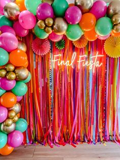 a colorful backdrop with balloons and streamers for a party or event that is going on