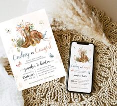 an image of wedding stationery and phone on the bed with flowers, leaves and feathers