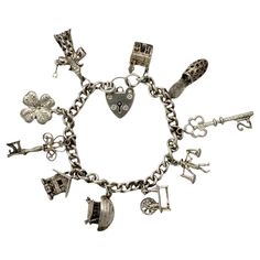 Delightful English sterling silver charm bracelet with a heart lock clasp. The safety chain is missing. There are ten charms: 2 x 21 keys, wizard, four leaf clover, opening house with a person inside, Noah's ark, trolley with a moving wheel, Chinese man carrying food, shoe, church. Measuring length approximately 17.6 cm / 6.9 inches. The clasp is hallmarked for 1978, the clasp and bracelet are marked for sterling silver. The bracelet is in very good condition, with scratching as expected. This i Measuring Length, Heart Lock, Chinese Man, Sterling Silver Charm Bracelet, Noah's Ark, Safety Chain, Noahs Ark, Silver Charm Bracelet, Leaf Clover