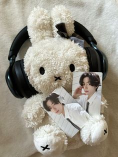 a white teddy bear with headphones around it's neck and an image of bts