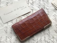 A small embossed croc leather small calling card case,  same brown leather interior, 9ct gold corner mounts hallmarked letter (m) : 1927,  English gold stamped 375 and P. or R. S & Co  maker's name. Inside sections two on each side and 2 stamp pockets.    The only thing to note is a little darkening to the leather on one side, mentioned for accuracy only, no more than you would expect for a nearly 100 year old little gem.  Five calling cards inside, I believe this belonged to Bertie Bath Oram Co Business Card Cases, Calling Card, Croc Leather, White Star, Gold Initial, Calling Cards, Leather Interior, Card Case, Purse Wallet