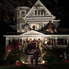 a large house decorated for halloween with people on the front porch