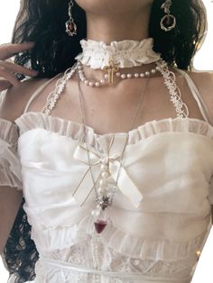 a close up of a woman wearing a white dress and necklace with cross on it