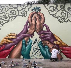 two men painting a mural on the side of a building with their hands covering each other's eyes