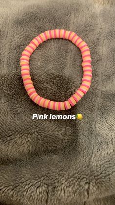 a pink and orange bracelet on top of a gray fur covered surface with the words pink lemons