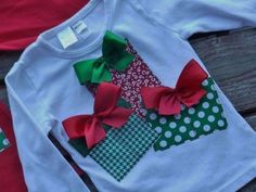 two shirts with bows on them are sitting on a wooden bench, one is green and the other is red