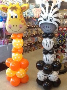 two inflatable giraffes and zebra balloons are on display at a store