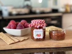 there is a jar of jam next to some fruit and crackers on the counter