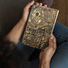 a person sitting on a couch holding a book in their hands and looking at it