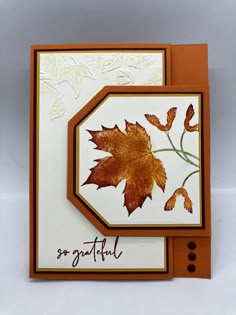 an orange and white greeting card with leaves on the front, and writing that says grateful