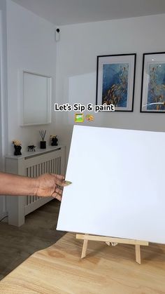 a woman is pointing at an easel with a white board in front of her