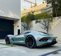 a blue sports car parked in front of a garage