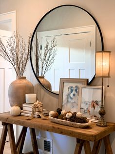 a wooden table topped with a mirror and pictures