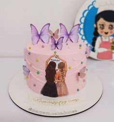 there is a pink cake with two girls on the top and butterflies on the side