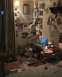 a messy bedroom with lots of clutter on the walls and desks in it