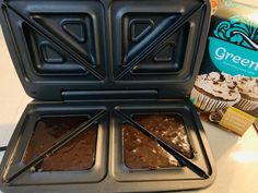 two cupcake pans with chocolate frosting in them next to a box of green tea