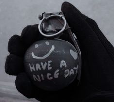 a hand holding a black ball with a smiley face on it