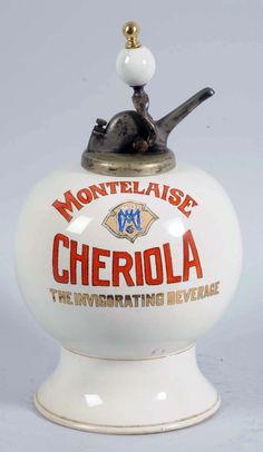 a white porcelain teapot with an orange and black logo on the top that says,'montellaise cherriola the inviting beverage '