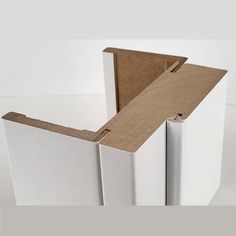 an open white box sitting on top of a table next to a piece of cardboard