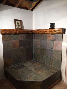 a bathroom with a wooden shelf above the bathtub and tile flooring on the walls