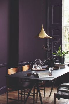 a dining room with purple walls and chairs