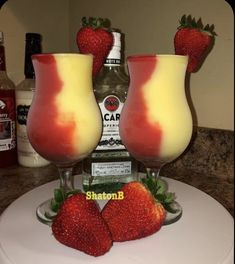 two glasses filled with liquid and strawberries