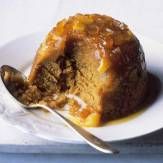 a piece of cake on a white plate with a fork and spoon next to it