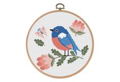 a cross stitch pattern with a blue bird and pink flowers in the hoop on a white background