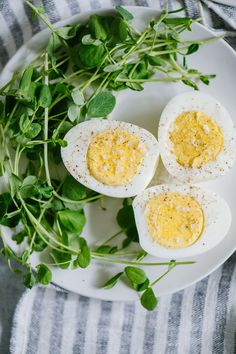 hard boiled eggs on a plate with greens