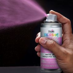 a person holding a spray can in their hand