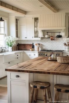 a kitchen with white cabinets and wooden counter tops