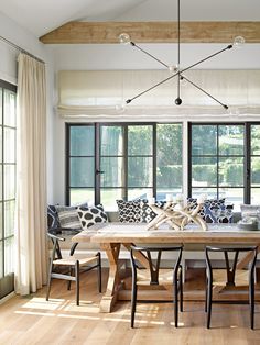 the dining room table is surrounded by black and white chairs, along with an upholstered bench