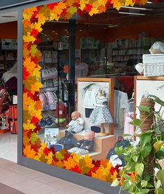 a store front with autumn leaves on the window