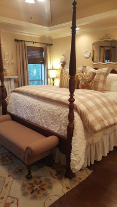 a bedroom with a four post bed and white bedspread on top of it