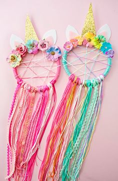 two unicorn ears made out of yarn with flowers on them