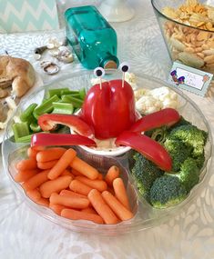 a plate with carrots, broccoli, cauliflower and crab on it